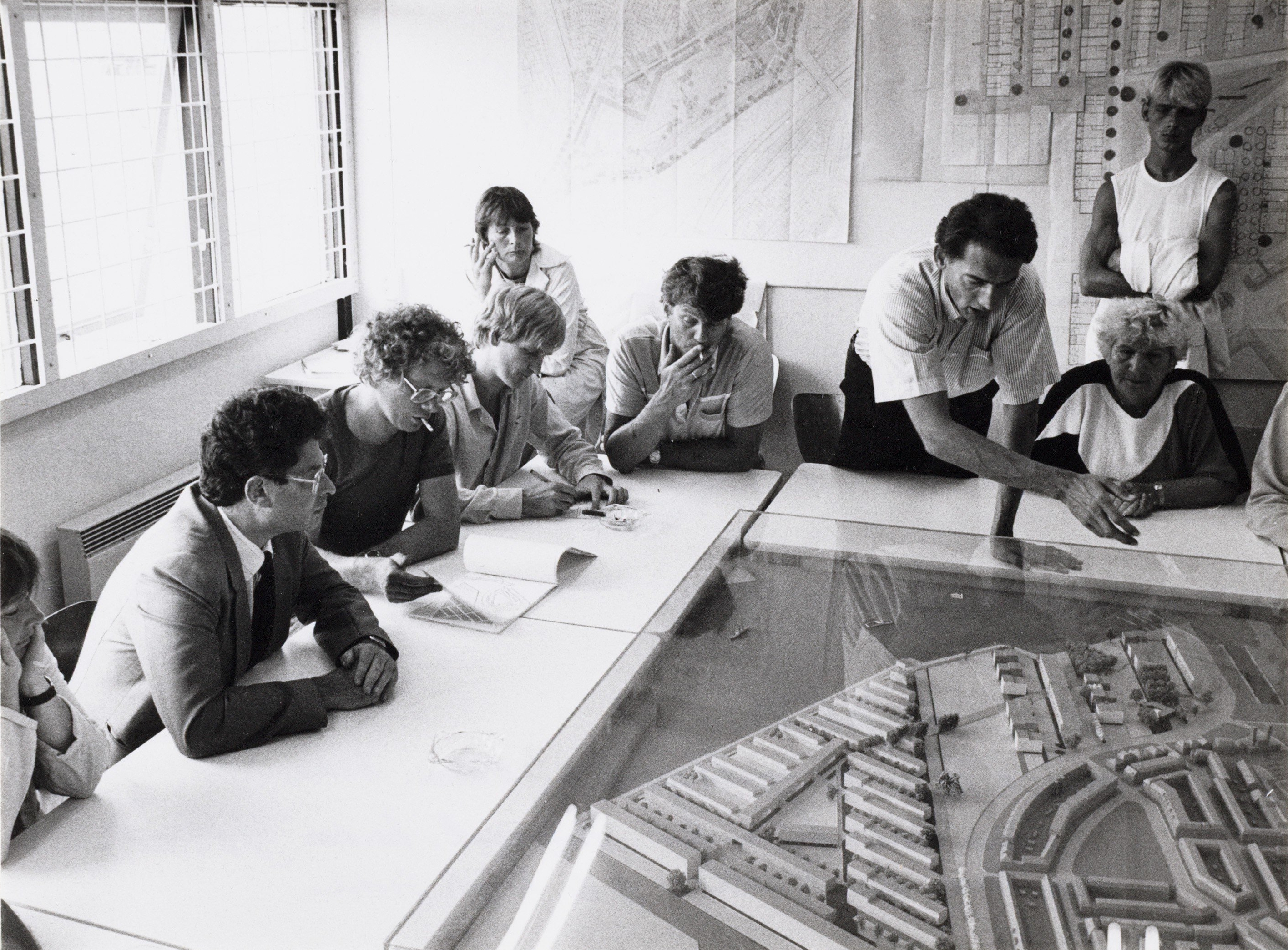 foto van een inspraakkantoor in 1983 waar architect Rem Koolhaas uitleg geeft aan toenmalig Burgermeester Ed van Thijn